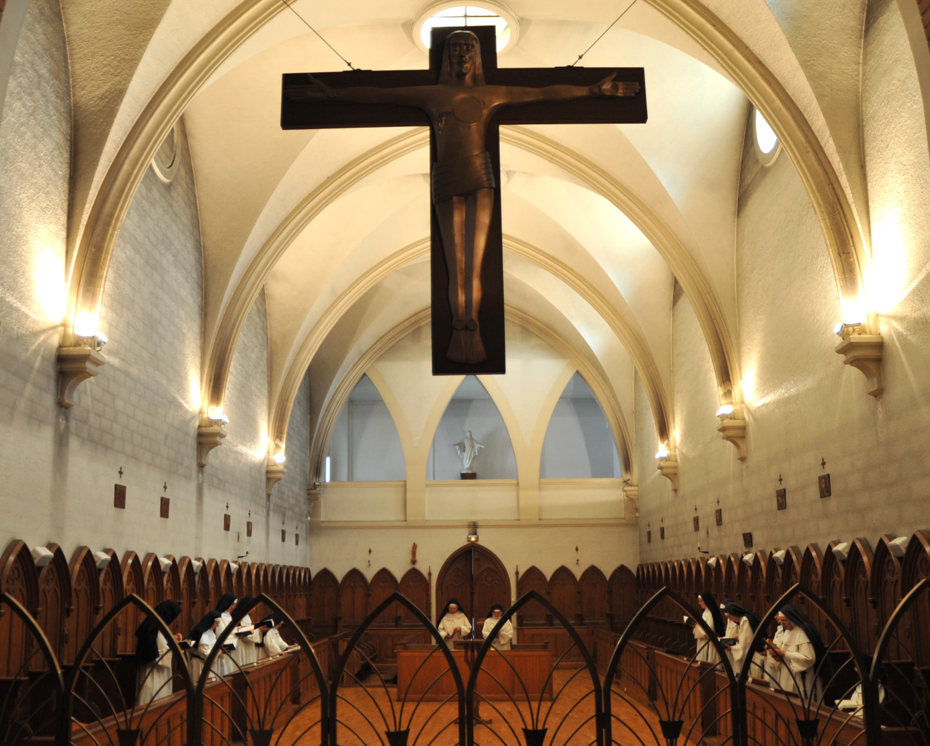 Moniales en prière dans le chœur sous le grand crucifix